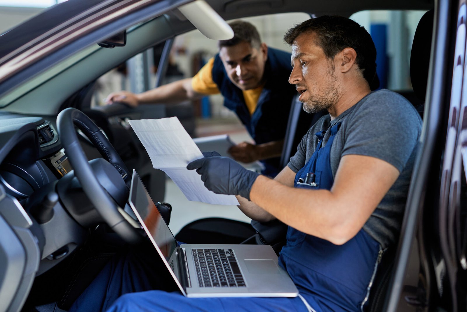 auto mechanic and his coworker car's performance in a repair sho